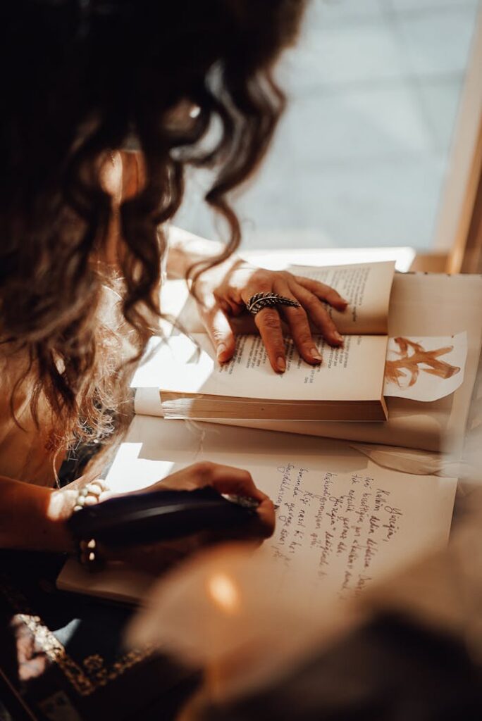 pexels photo 7080728 Crop anonymous female with dark hair sitting near window at retro writing cabinet while taking notes with feather in vintage store