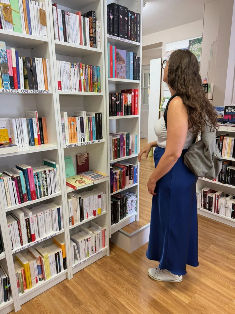 Laura Goncalves a olhar para estante de livros numa livraria.